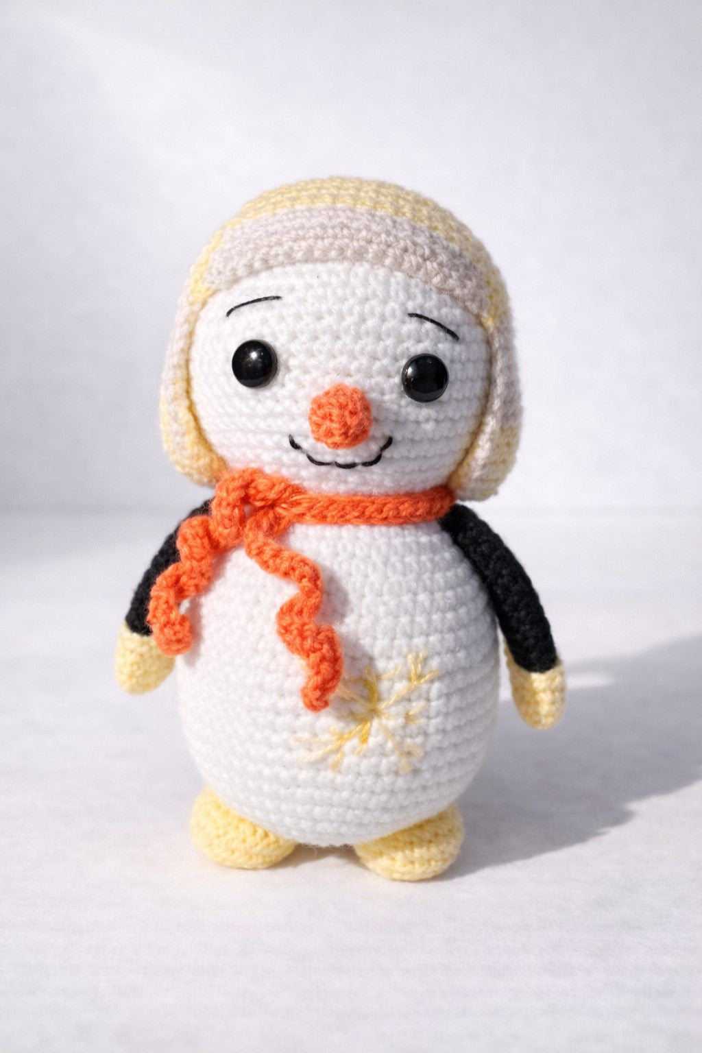 Crocheted penguin toy with a white background