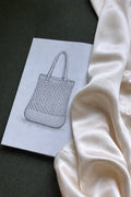 Crocheted bag design on paper with yarn and silk lining.