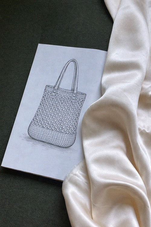 Crocheted bag design on paper with yarn and silk lining.
