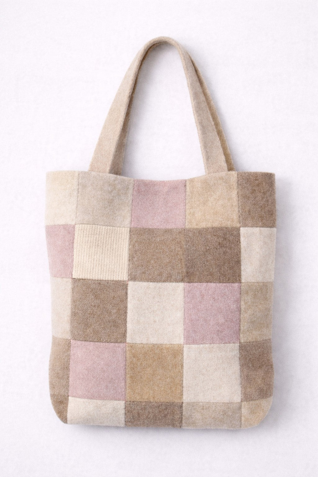 Checkered tote bag with beige, pink, and brown squares on a white background